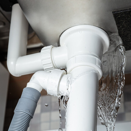 Close-up Of Water Is Leaking From The White Sink Pipe